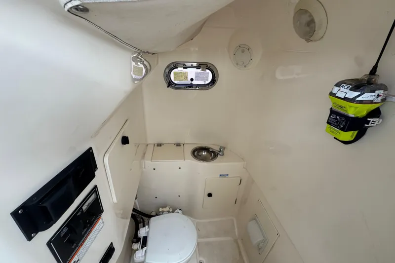 Slide: The Image of Interior of 2011 Pursuit C 280 Center Console boat with compact bathroom amenities. - 14