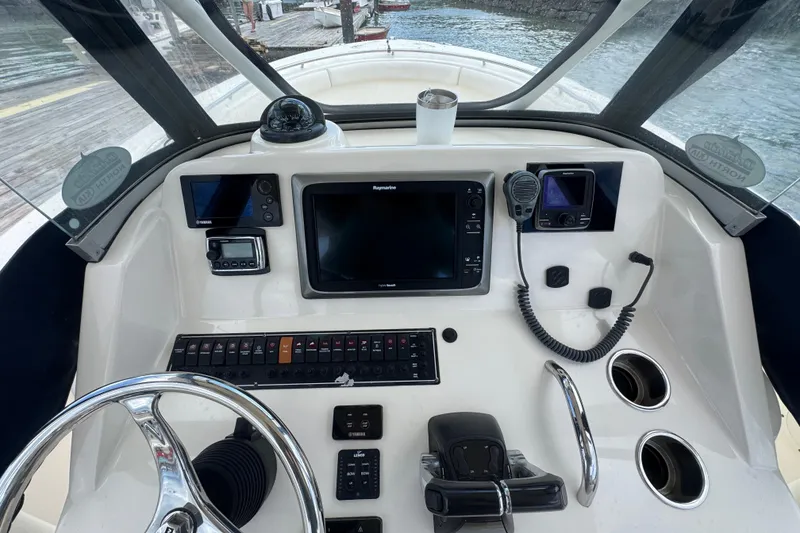 Slide: The Image of 2011 Pursuit C 280 Center Console helm with navigation equipment and steering wheel. - 4