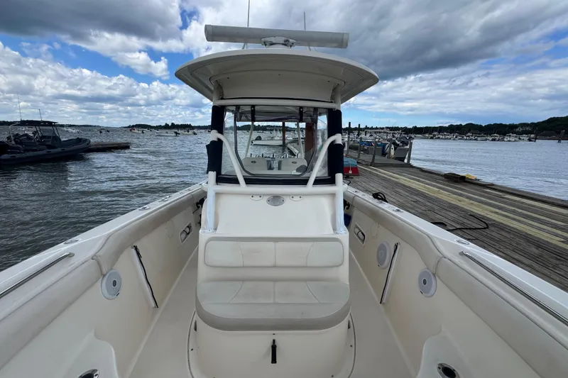 Slide: The Image of 2011 Pursuit C 280 Center Console boat docked by the waterfront under cloudy skies. - 7