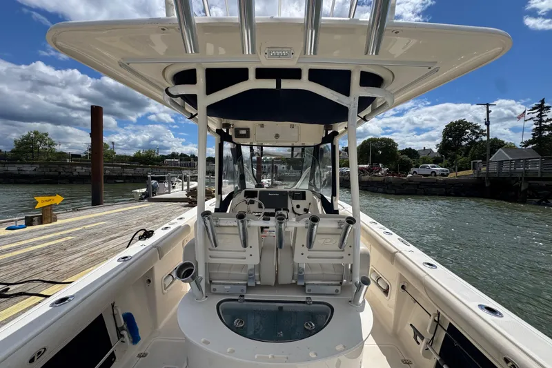 Slide: The Image of 2011 Pursuit C 280 Center Console boat docked by a scenic waterfront. - 9
