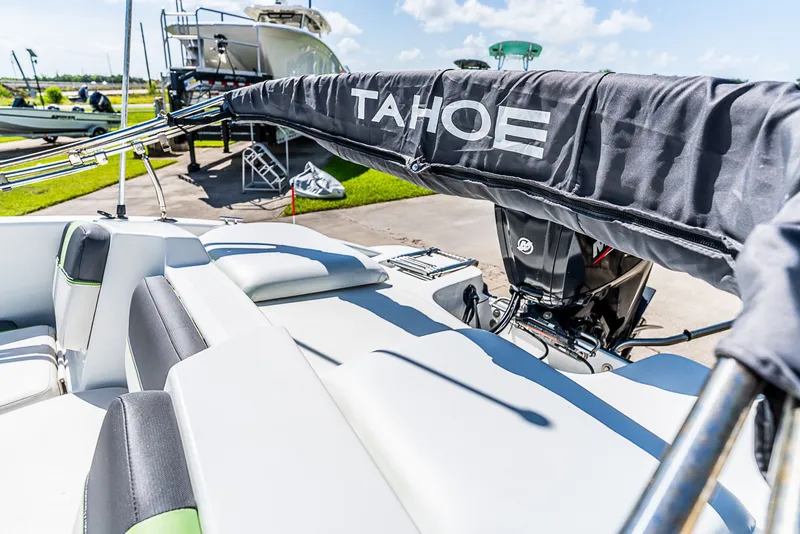 Slide: The Image of A 2021 Tracker Tahoe boat with cushioned seats and an outboard motor, on a trailer. - 10