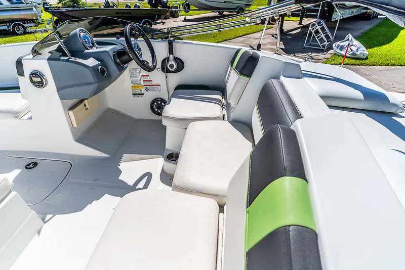 Slide: The Image of The image shows the cockpit of a 2021 Tracker Tahoe boat with white and green seats. - 9
