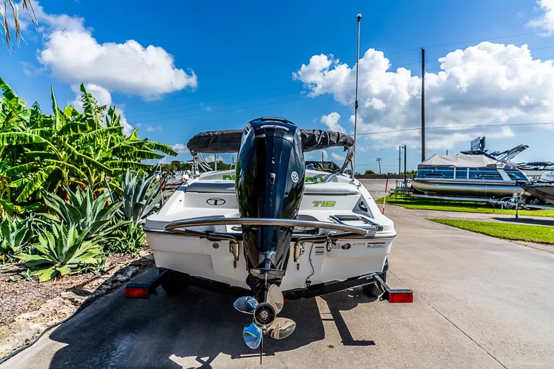 Slide: The Image of A 2021 Tracker Tahoe boat on a trailer, surrounded by plants and a clear sky. - 4