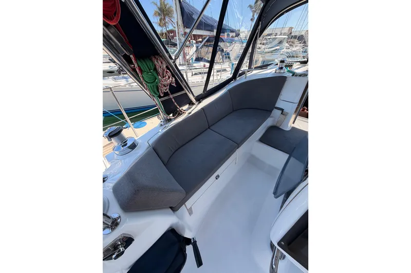 Slide: The Image of 2008 Hunter 45 Deck Salon cockpit with cushioned seating and marina view. - 100