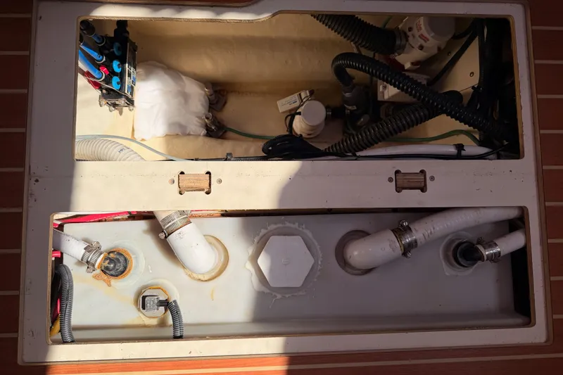 Slide: The Image of Engine compartment of a 2008 Hunter 45 Deck Salon sailboat, showing hoses and wiring. - 106