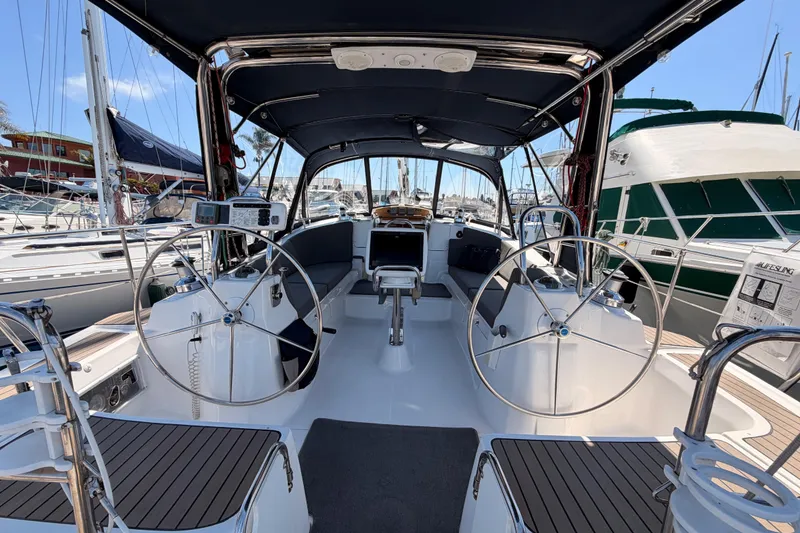 Slide: The Image of 2008 Hunter 45 Deck Salon yacht interior with dual steering wheels in marina setting. - 15