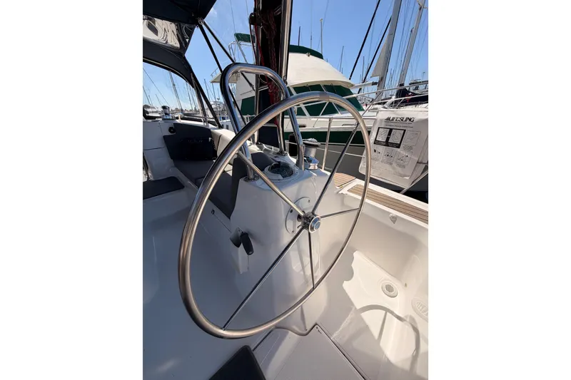 Slide: The Image of Steering wheel of a 2008 Hunter 45 Deck Salon sailboat in a marina setting. - 24