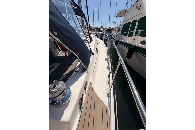 Slide: The Image of 2008 Hunter 45 Deck Salon yacht docked, showcasing sleek deck design and marina setting. - 25