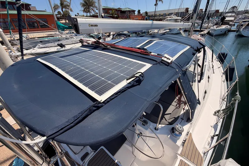 Slide: The Image of 2008 Hunter 45 Deck Salon sailboat with solar panels docked at a marina. - 26