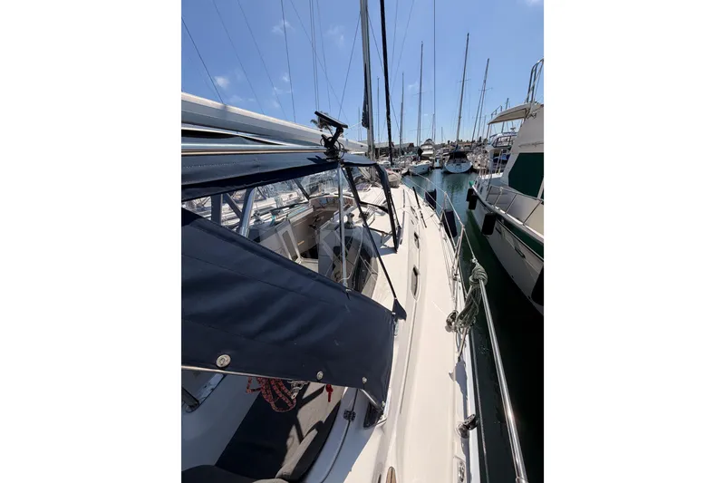 Slide: The Image of 2008 Hunter 45 Deck Salon sailboat docked in a marina under clear blue skies. - 27
