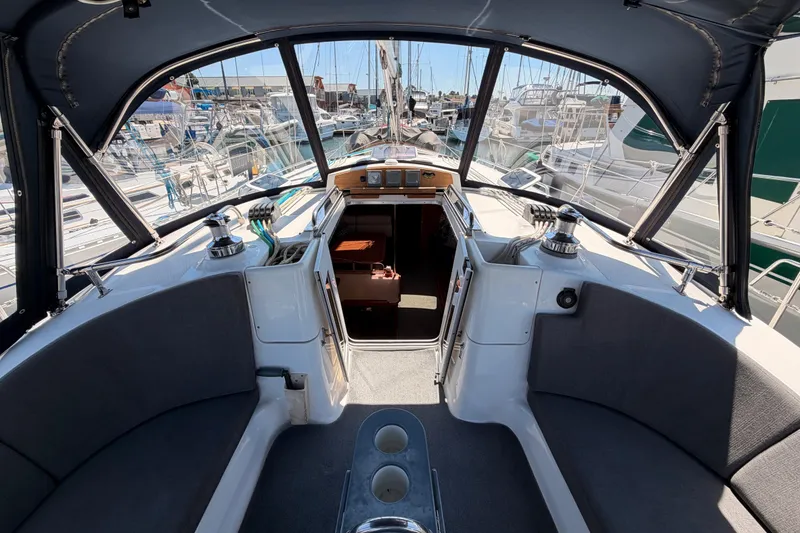 Slide: The Image of 2008 Hunter 45 Deck Salon cockpit with marina view, featuring seating and navigation equipment. - 43