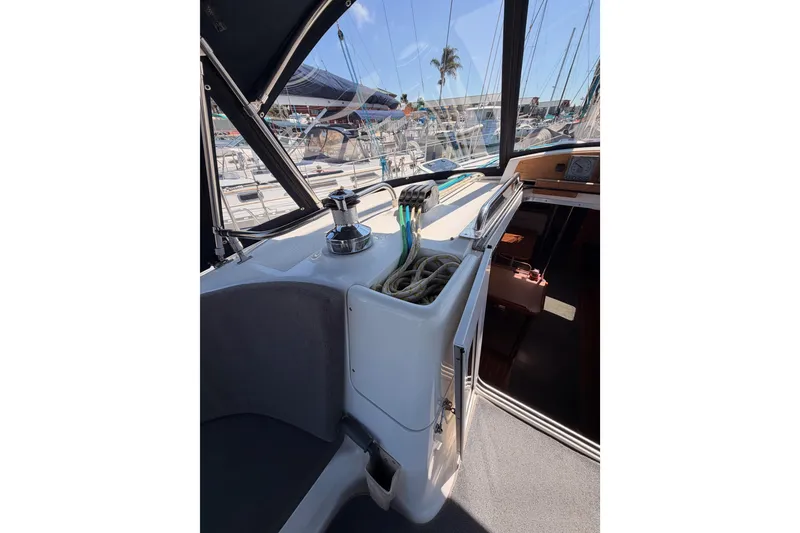 Slide: The Image of 2008 Hunter 45 Deck Salon cockpit with winch, ropes, and marina view. - 45