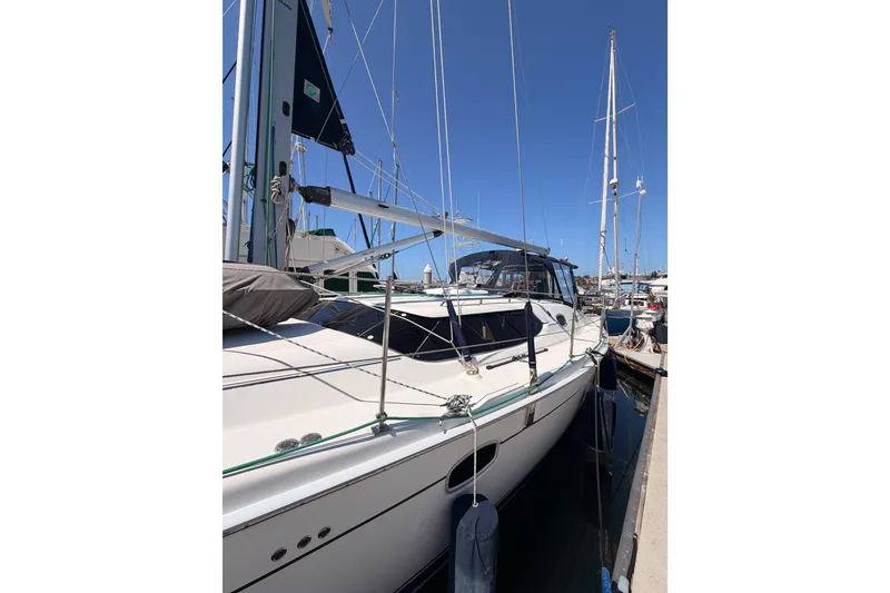 Slide: The Image of 2008 Hunter 45 Deck Salon sailboat docked at marina under clear blue sky. - 5