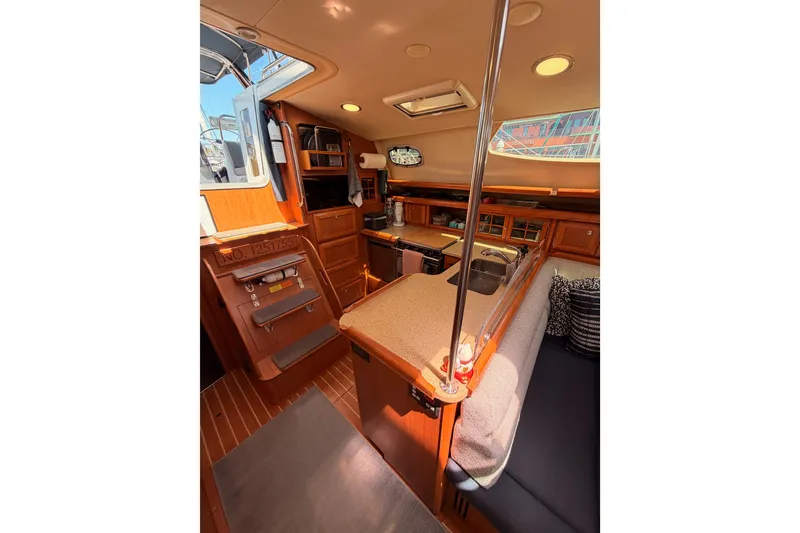 Slide: The Image of Interior of 2008 Hunter 45 Deck Salon yacht, featuring a cozy kitchen and seating area. - 50
