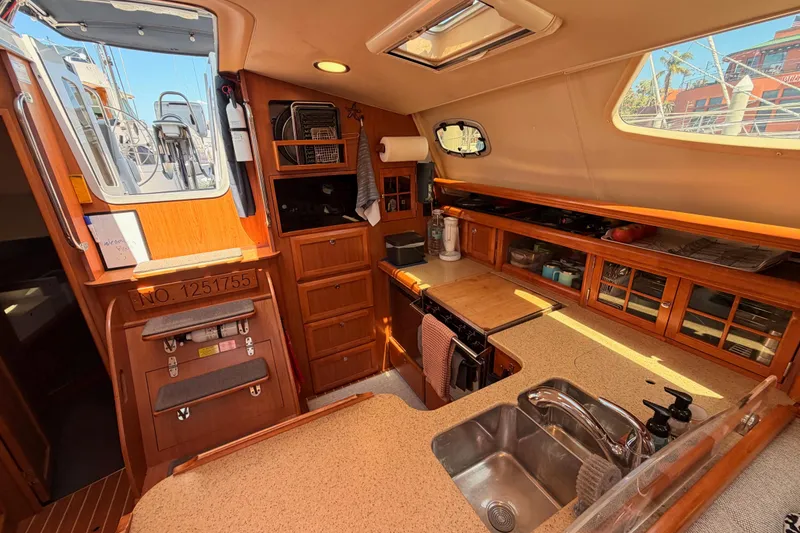 Slide: The Image of Interior of 2008 Hunter 45 Deck Salon yacht, featuring a well-equipped kitchen area. - 51