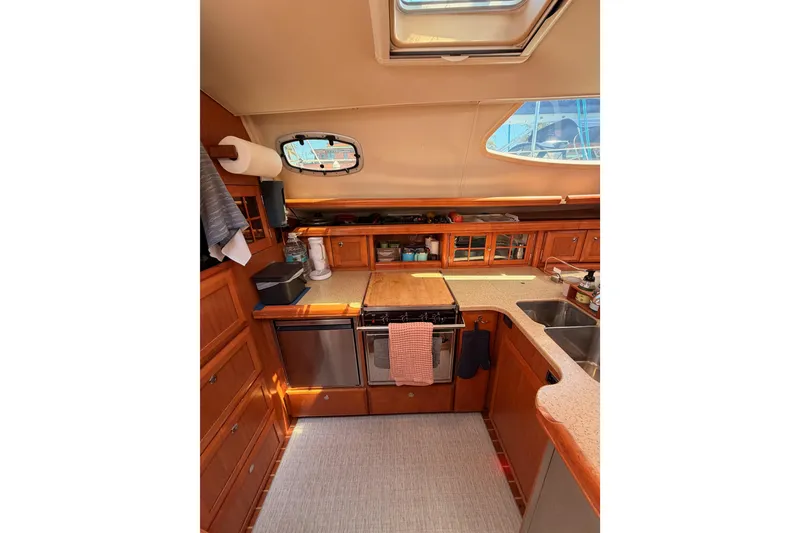 Slide: The Image of Interior of 2008 Hunter 45 Deck Salon yacht kitchen with wooden cabinetry and modern appliances. - 53