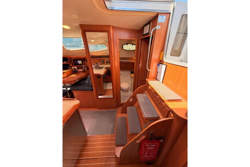 Slide: The Image of Interior of 2008 Hunter 45 Deck Salon yacht, featuring wooden finishes and cozy seating. - 57