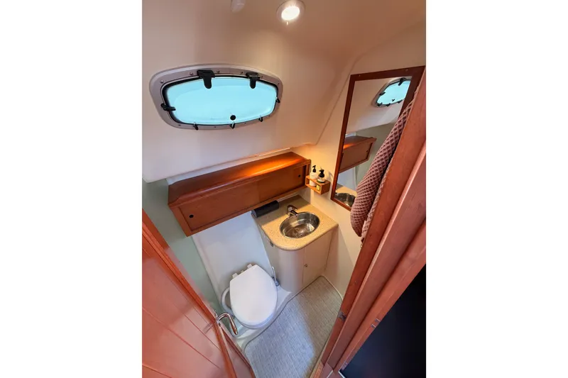 Slide: The Image of Compact bathroom in 2008 Hunter 45 Deck Salon yacht with sink, toilet, and window. - 58