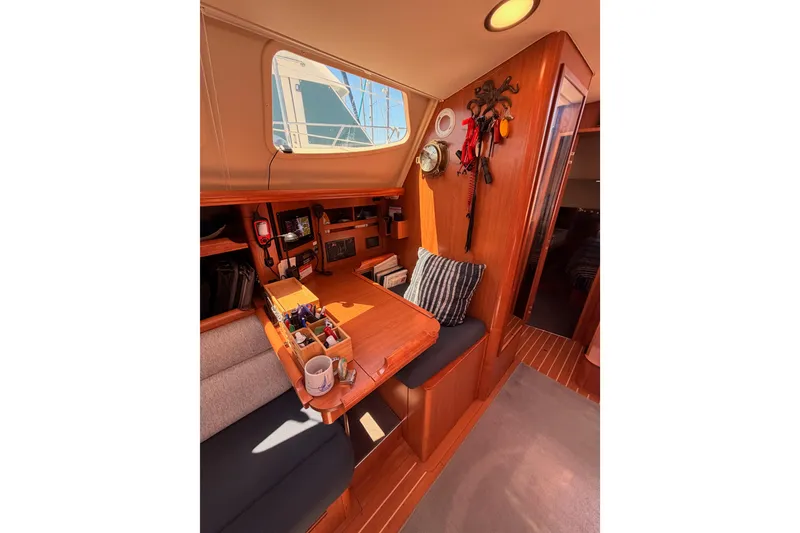 Slide: The Image of Interior of 2008 Hunter 45 Deck Salon, featuring a cozy navigation station and seating area. - 63