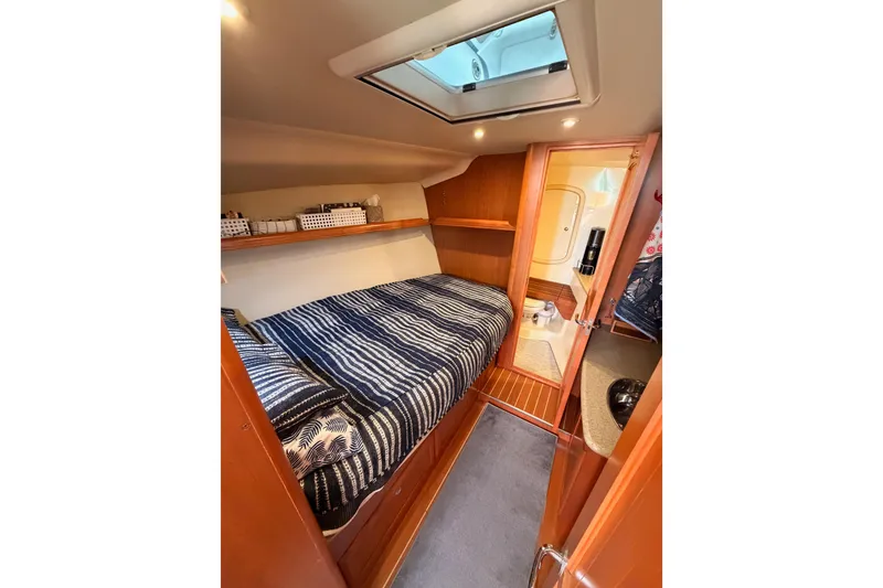 Slide: The Image of Cozy cabin interior of 2008 Hunter 45 Deck Salon yacht with striped bedding. - 75