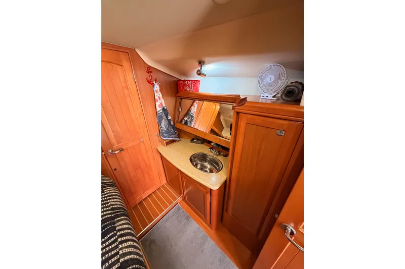 Slide: The Image of Interior of 2008 Hunter 45 Deck Salon with wooden cabinetry and compact sink area. - 76