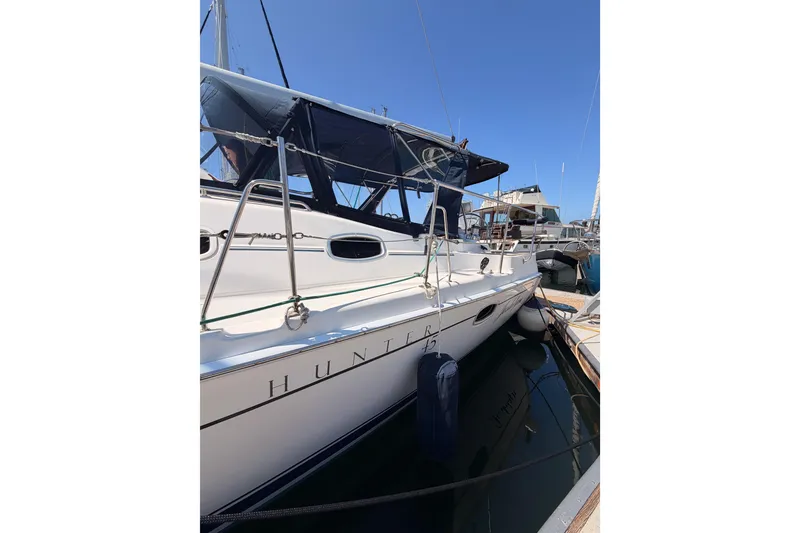 Slide: The Image of 2008 Hunter 45 Deck Salon yacht docked at marina under clear blue sky. - 8