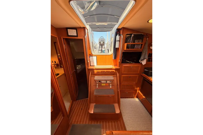 Slide: The Image of Interior of 2008 Hunter 45 Deck Salon yacht with wooden cabinetry and steps. - 87