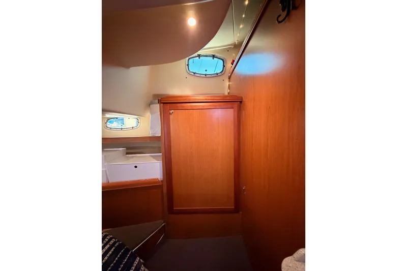 Slide: The Image of Interior of 2008 Hunter 45 Deck Salon with wooden cabinetry and porthole window. - 92
