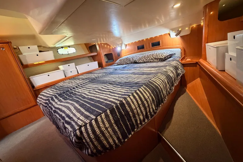 Slide: The Image of Cozy cabin interior of 2008 Hunter 45 Deck Salon with striped bedding and storage. - 94