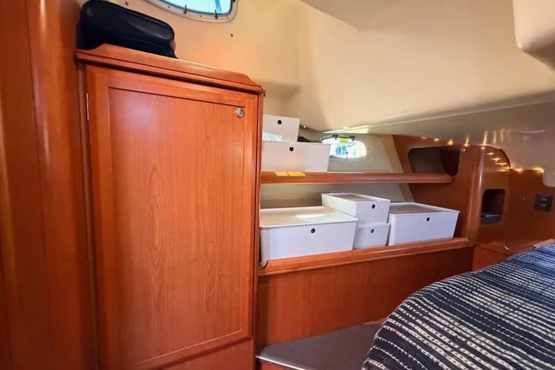 Slide: The Image of Interior of 2008 Hunter 45 Deck Salon with wooden cabinetry and organized storage boxes. - 96