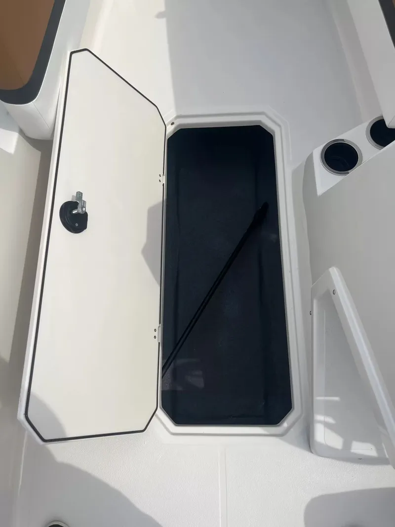Slide: The Image of An open storage hatch on a boat with a black interior and cup holders. - 5
