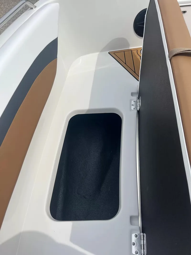 Slide: The Image of The image shows a storage compartment on a 2027 Starcraft SVX 171 OB boat with cushioned seating. - 6