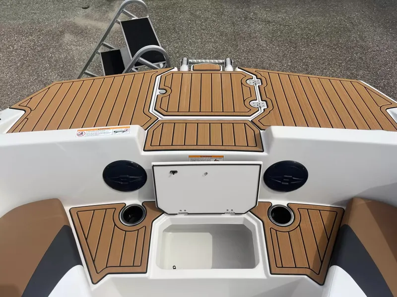 Slide: The Image of The image shows the deck of a Starcraft SVX 171 OB boat with wood-like finish and storage. - 7