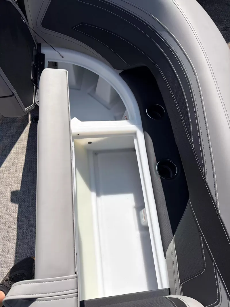 Slide: The Image of A gray seat cushion on a boat with built-in storage and cup holders. - 16