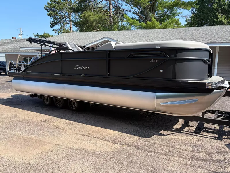 Slide: The Image of A sleek Barletta Cabrio C22UC/TT pontoon boat from 2027 sits on a trailer in front of a building. - 17