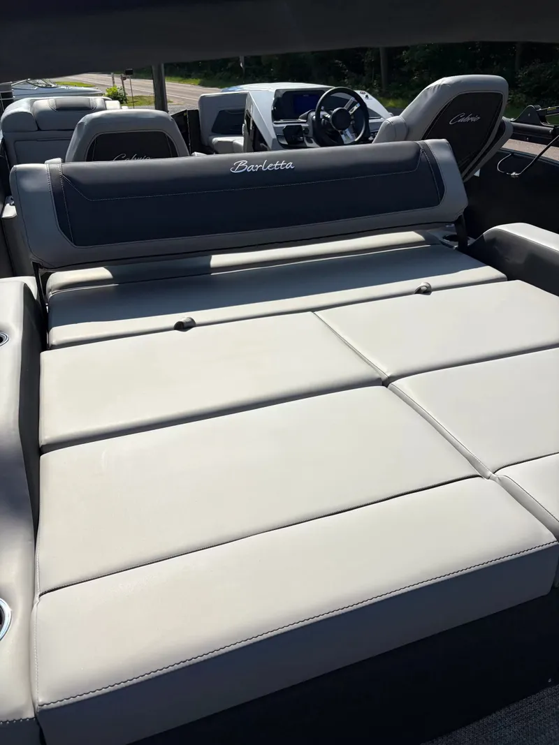 Slide: The Image of The image shows the spacious, cushioned lounge area of a Barletta CABRIO C22UC/TT boat. - 10