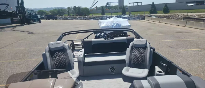 Slide: The Image of The image shows the interior of a 2026 Sylvan X3 ULZ FG/TT pontoon boat parked in a lot. - 9