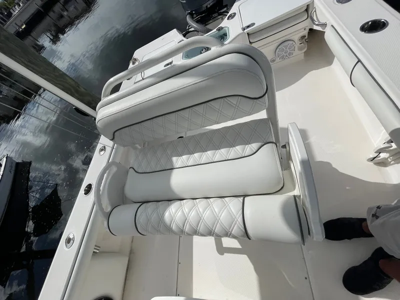 Slide: The Image of A white seat with quilted pattern on a boat, surrounded by water and deck. - 11
