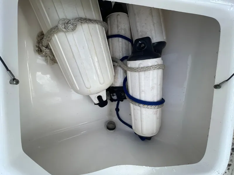 Slide: The Image of A storage compartment with several fenders secured by ropes. - 19