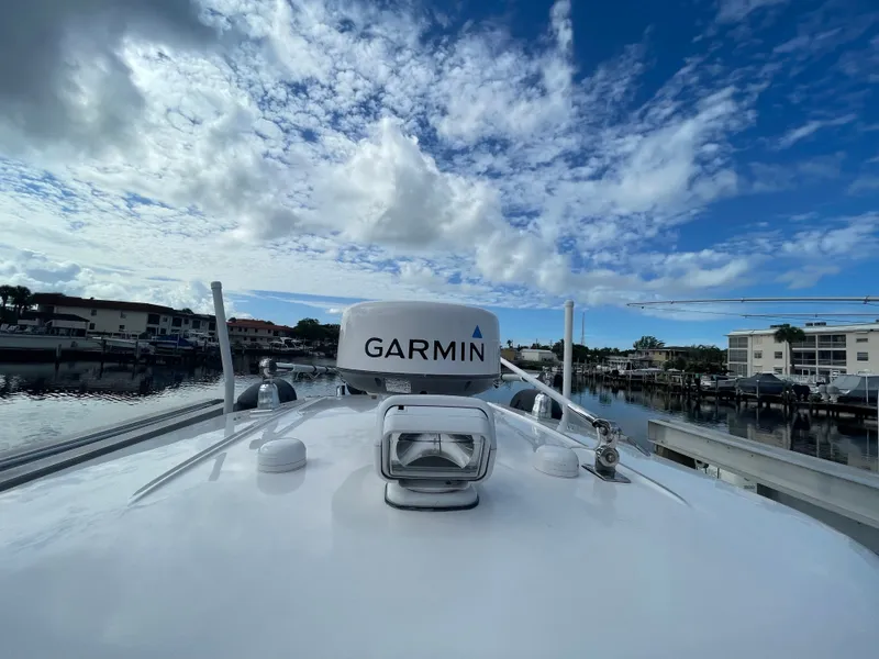 Slide: The Image of A 2012 Everglades 243 Center Console boat docked in a marina. The sky is cloudy. - 20