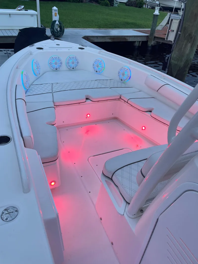 Slide: The Image of The image shows the cockpit of a 2012 Everglades 243 Center Console boat with pink lighting. - 23