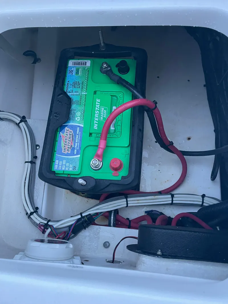 Slide: The Image of A green boat battery is installed in a white compartment, surrounded by cables. - 35