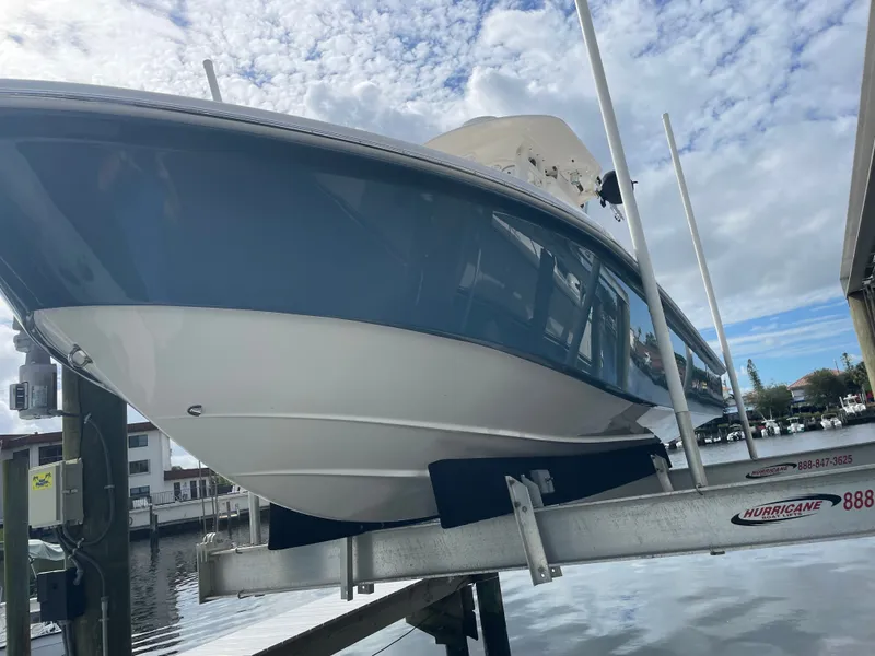 Slide: The Image of A 2012 Everglades 243 Center Console boat on a lift by the water. - 4