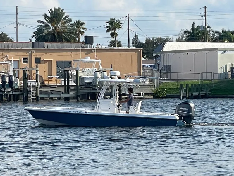Slide: The Image of A blue and white boat on calm water, with buildings in the background. - 5