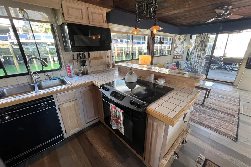 Slide: The Image of Cozy 1993 Sumerset houseboat kitchen with wooden cabinets, stove, and waterfront view. - 10