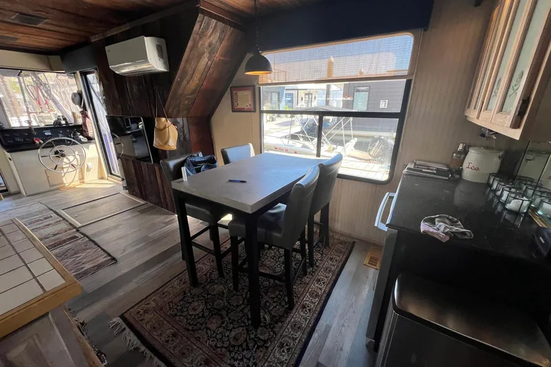 Slide: The Image of Interior of a 1993 Sumerset houseboat with dining area and helm, featuring rustic wood accents. - 13