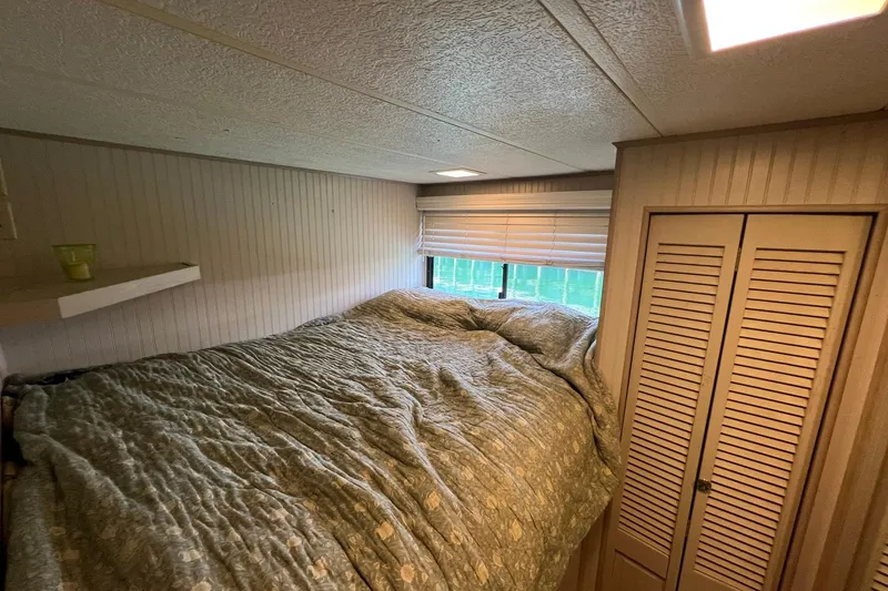 Slide: The Image of Cozy bedroom interior of a 1993 Sumerset houseboat with a bed and wooden closet. - 15