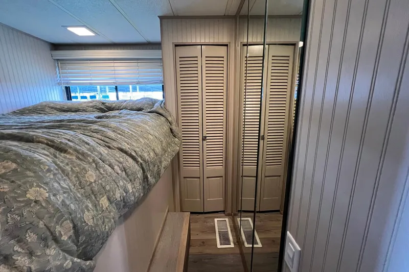 Slide: The Image of Cozy 1993 Sumerset houseboat interior with bed, mirrored closet, and wooden paneling. - 16