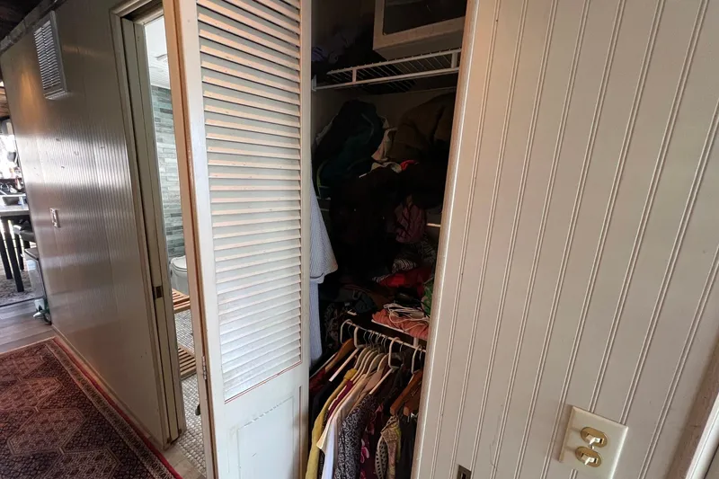 Slide: The Image of 1993 Sumerset houseboat interior with open closet and visible bathroom. - 20