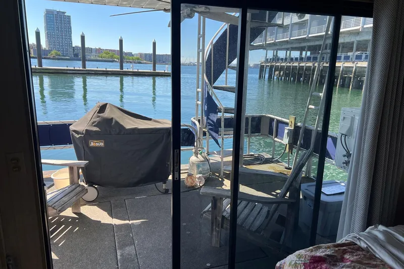 Slide: The Image of Houseboat deck view with grill, chairs, and waterfront scenery. Sumerset model, 1993. - 25